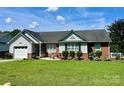 Inviting one-story home with manicured lawn, brick facade, and black shuttered windows at 1700 Pickwick Ave, Kannapolis, NC 28083