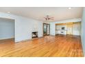Spacious living room with hardwood floors, brick fireplace, and an open transition to the kitchen at 203 Ewing Dr, Belmont, NC 28012