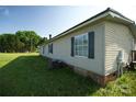 A side view of the home highlighting its vinyl siding and window details, offering a glimpse of the backyard at 302 Edwards Rd, Mooresville, NC 28115