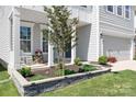Landscaped front yard featuring a lovely tree and well-maintained stone garden bed at 3038 Burnello Ct, Iron Station, NC 28080