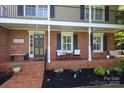 Inviting brick porch featuring seating, planters, and a welcoming entrance to the beautiful brick home at 3604 Golfview Dr, Gastonia, NC 28056