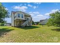 Home exterior with covered back porch and spacious backyard with green grass and blue sky at 4111 Alexis Sw Ct, Concord, NC 28027