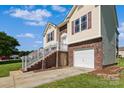 Brick and siding home with attached garage, landscaped front yard, and inviting staircase at 4111 Alexis Sw Ct, Concord, NC 28027