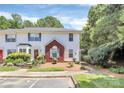 Charming two-story townhome featuring white siding, a brick facade, and a well-manicured front yard with lush landscaping at 4263 Melrose Club Dr, Matthews, NC 28105
