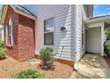 Side view of a bright two-story house with white siding and brick details with neatly manicured landscaping and a walkway at 4263 Melrose Club Dr, Matthews, NC 28105