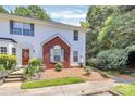 Charming two-story townhome featuring white siding, a brick facade, and a well-manicured front yard with lush landscaping at 4263 Melrose Club Dr, Matthews, NC 28105