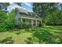 Quaint single-story home with a covered front porch, brick foundation, and lush greenery in a serene setting at 4612 Rehobeth Rd, Waxhaw, NC 28173