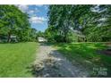 Spacious property showcasing a traditional home with a long gravel driveway, mature trees, and outbuildings at 4612 Rehobeth Rd, Waxhaw, NC 28173