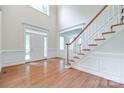 Bright, open foyer with hardwood floors, staircase, and large windows creating a grand entrance at 5008 Woodview Ln, Weddington, NC 28104