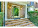 Elegant front entrance with brick steps, white trim, and a glass door, creating a welcoming view at 5008 Woodview Ln, Weddington, NC 28104