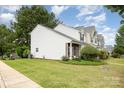 Townhouse exterior with lush green lawn, brick details, and clean white siding, offering a serene street view at 6103 Warrior Ave, Fort Mill, SC 29707