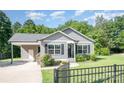 Inviting front exterior showcasing gray siding, black shutters, green grass and a covered carport at 613 Gold Hill Dr, Salisbury, NC 28146