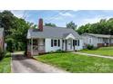 A cozy home with white siding, black shutters, and a well-maintained lawn at 626 1St Se Ave, Hickory, NC 28602