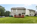 Home's rear exterior features a spacious yard and small wooden deck at 9637 Brookmere Ln, Charlotte, NC 28214