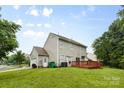 Rear exterior view showing the wooden deck, garage, and nicely maintained lawn at 9637 Brookmere Ln, Charlotte, NC 28214