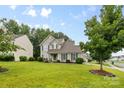 Traditional two-story home with a lovely green lawn and mature shade trees at 9637 Brookmere Ln, Charlotte, NC 28214