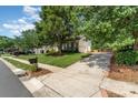 Inviting single-Gathering home boasts a well-manicured lawn, mature trees, and a long driveway leading to an attached garage at 1002 Hollyhedge Ln, Indian Trail, NC 28079