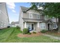 Inviting two-story townhouse featuring a covered porch and well-maintained landscaping at 1012 Laparc Ln, Indian Trail, NC 28079