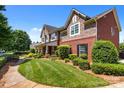 Side view of a charming two-story home featuring brick and stone accents and manicured lawn at 126 Northbridge Dr, Mooresville, NC 28115