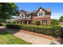 Charming two-story home featuring brick and stone accents, a covered porch, and mature landscaping at 126 Northbridge Dr, Mooresville, NC 28115