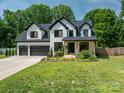 Charming two-story white home featuring black trim, front porch, and well-maintained landscaping at 140 Robin Rd, Lincolnton, NC 28092