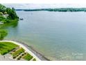 Expansive waterfront view with manicured grounds, showcasing the serene lakeside living this property offers at 14053 Queens Harbor Rd, Charlotte, NC 28278