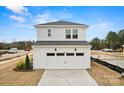 Two-car garage with white doors and an expansive driveway, offering ample parking at 15906 Parkside Crossing Dr # 317, Charlotte, NC 28273