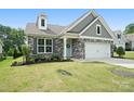 Inviting home with stone and gray siding, enhanced by lush landscaping and a green lawn at 16112 Langston Dr, Charlotte, NC 28278