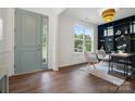 Bright living room with elegant gray chairs, a large window and a decorative black bookcase at 16112 Langston Dr, Charlotte, NC 28278