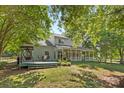 Expansive backyard with a porch swing, patio furniture, and lush green lawn at 1624 Moonstone Dr, Matthews, NC 28105