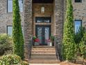 Inviting entryway featuring a brick facade, black double doors, and manicured greenery on either side of the steps at 172 Barber Loop, Mooresville, NC 28117