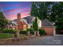 Beautiful brick home featuring a stone fence and manicured landscaping at 2100 Chesterfield Ave, Charlotte, NC 28205