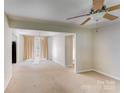 Bright living room with ceiling fan, carpet floors, and access to kitchen and dining area at 2105 Florida Ave, Kannapolis, NC 28083