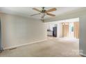 Bright living room with ceiling fan, carpet floors, and access to kitchen and sliding glass door at 2105 Florida Ave, Kannapolis, NC 28083