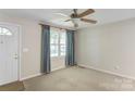 Bright living room with ceiling fan, carpet floors, and window with curtains at 2105 Florida Ave, Kannapolis, NC 28083