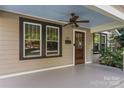 Inviting front porch showcasing a ceiling fan and a classic wooden front door with a glass insert at 2112 Shenandoah Ave, Charlotte, NC 28205