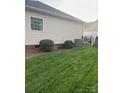 A well-maintained backyard with green grass, bushes, AC unit and a fence at 2300 Wednesbury Ct, Kannapolis, NC 28083