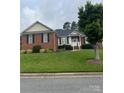 Beautiful single-story brick home with a green lawn and attractive landscaping at 2300 Wednesbury Ct, Kannapolis, NC 28083