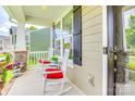 Comfortable front porch featuring white rocking chairs with red cushions and views of the neighborhood at 2816 Woodlands Creek Dr, Monroe, NC 28110