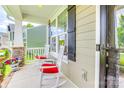 Front porch featuring white rocking chairs with red cushions at 2816 Woodlands Creek Dr, Monroe, NC 28110