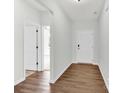 Bright entryway with hardwood floors, featuring a view into another room and white doors at 3207 Selwyn Landing Dr, Charlotte, NC 28215