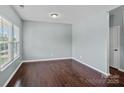 Well-lit bedroom with hardwood floors, neutral paint, large window, and a white door at 321 Almora Loop, Mooresville, NC 28115