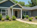 Close up of a front door and porch with meticulous landscaping around the property at 429 Summer Ridge Dr, Stanley, NC 28164