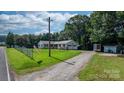 Scenic home exterior with a long driveway, spacious lawn, and mature trees at 4395 Burton Rd, Maiden, NC 28650