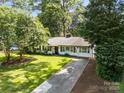 Landscaped front yard of a traditional home with a long driveway and mature trees at 5329 Valley Forge Rd, Charlotte, NC 28210