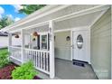 Inviting front porch with hanging plants, a welcome mat, and a charming seating area at 6705 Reddman Rd, Charlotte, NC 28212