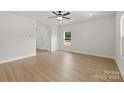 Bright living room with wood-look flooring, neutral walls, and ceiling fan at 7129 Jerimoth Dr, Charlotte, NC 28215