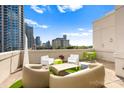 Wide angle view of a rooftop patio with an urban view, designer furniture, and turf at 715 N Church St # 513, Charlotte, NC 28202