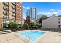 A private fenced swimming pool at condo building surrounded by lounge chairs and greenery at 715 N Church St # 513, Charlotte, NC 28202