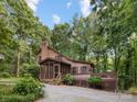 Charming wood home with a screened-in porch, a deck, a brick chimney and lovely landscaping at 715 White Oaks Cir, Monroe, NC 28110